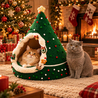 Two cats with the Christmas tree cat cave by the fireplace
