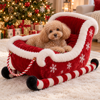 Red Christmas sleigh pet bed with a toy poodle inside next to a Christmas tree
