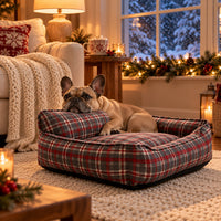 French Bulldog resting its chin on the backrest of the plaid bed in a cozy winter reading nook